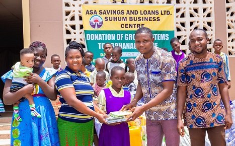 Mr David Amevor (second from right), Suhum Area Manager of ASA Savings and Loans handing over items to Ms Doris Otemah, Caregiver at the Jehovah Rapha Orphanage as Mr George Ntim (far right), Suhum Branch Manager and another caregiver and the children looked on.